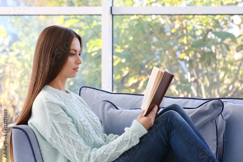 Young woman reading book si...
