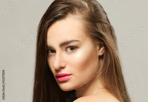 Portrait of beautiful young woman on grey background, close up