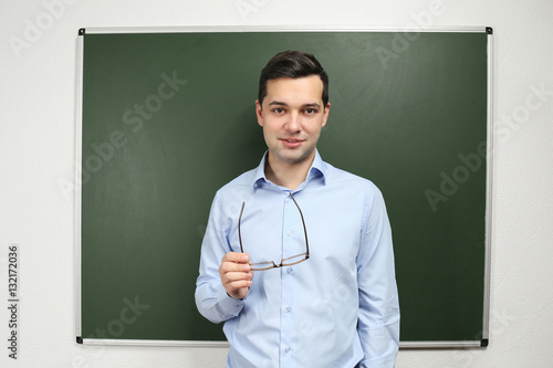 Handsome young teacher stan...