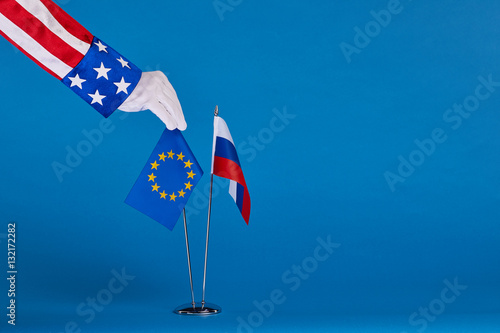 Two flags and hand on a blue background, the political concept