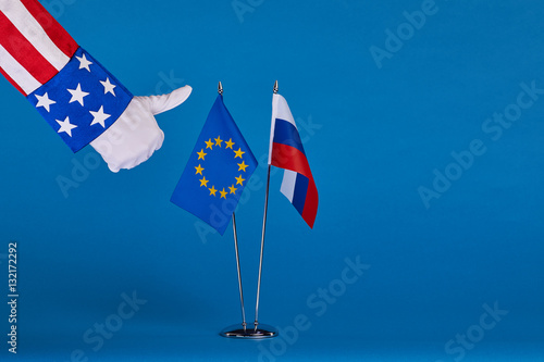 Two flags and hand on a blue background, the political concept