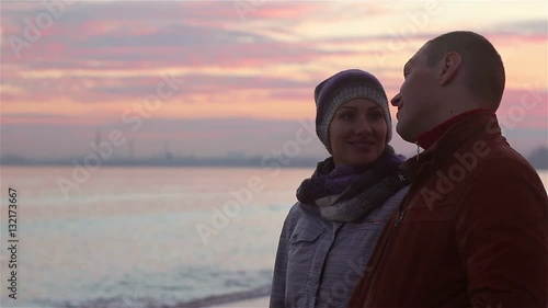 young couple walking on the beach at evening in winter.