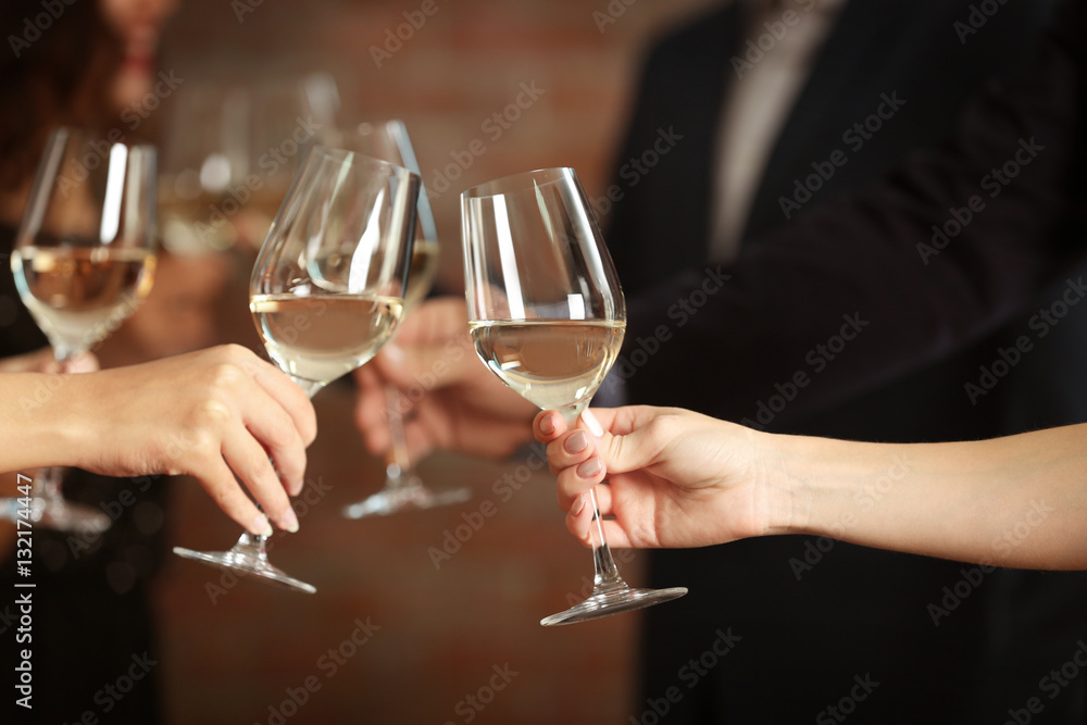 Female hands toasting with glasses of white wine, closeup