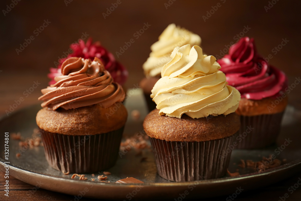 Metal tray with tasty chocolate cupcakes on wooden table, close up