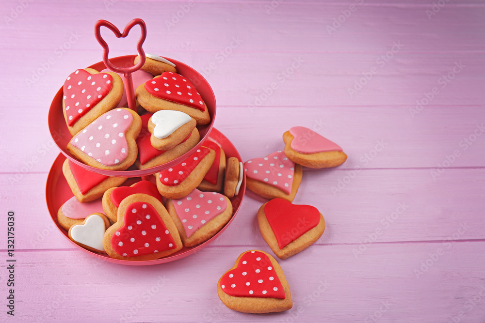 Valentine's day cookies on stand against wooden background Valentine's day cookies on stand against wooden background