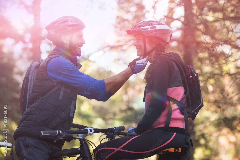 Man adjusting bicycle helmet of woman Man adjusting bicycle helmet of woman