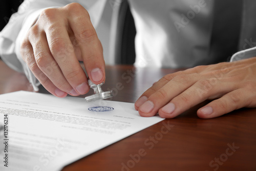 Notary public in office stamping document photo