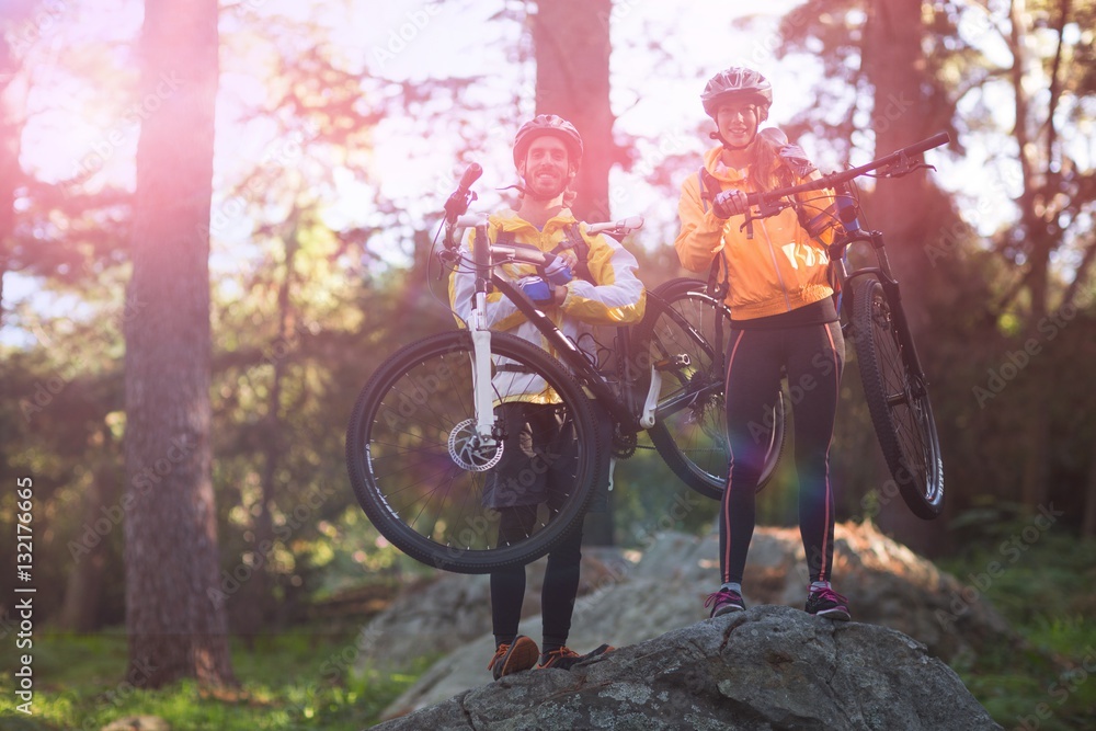 Portrait of biker couple carrying mountain bike Portrait of biker couple carrying mountain bike