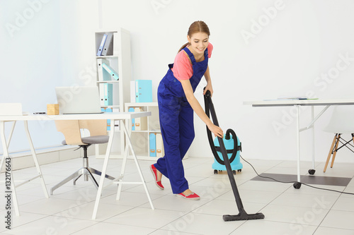 Professional cleaner cleaning floor in office