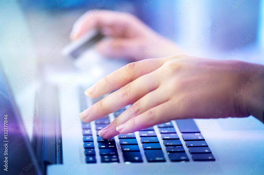 Young woman hands holding credit card and using laptop computer for online shopping, e-banking Young woman hands holding credit card and using laptop computer for online shopping, e-banking