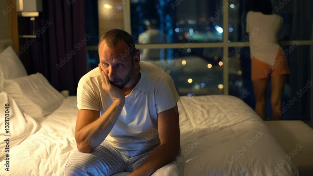 Sad, unhappy couple having sexual problems in bedroom at night
Sad, unhappy couple having sexual problems in bedroom at night