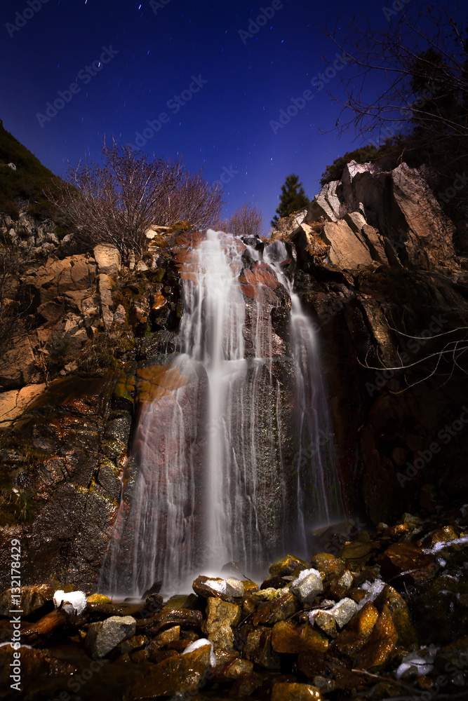 Waterfall in moonlight with stars
