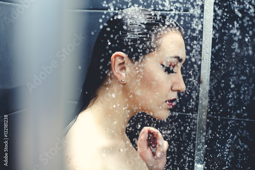 Beautiful sexy young woman washing body in a shower