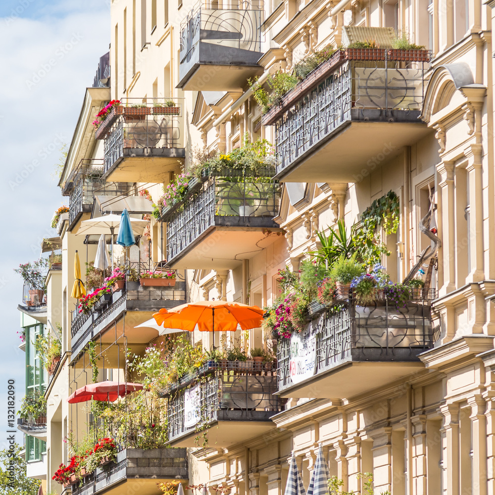 Traditional European residential house with balconys with colorful flowers and flowerpots. Kreuzberg neighborhood, Berlin, Germany,