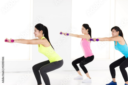 young woman doing exercise with dumbbell in gym © Tom Wang