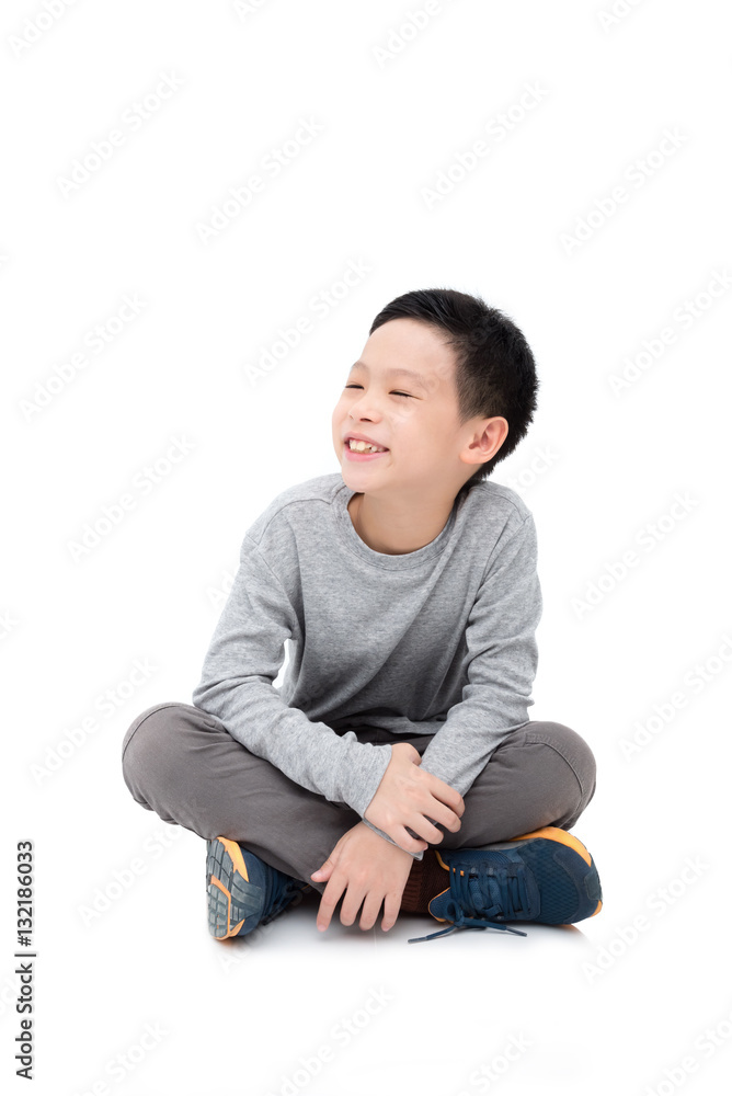 Young asian boy sitting and smiles over white background