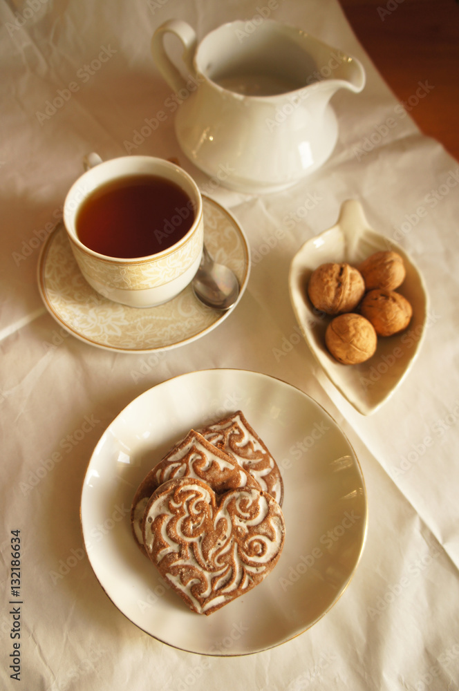 White cup of tea with cookies in form of heart 