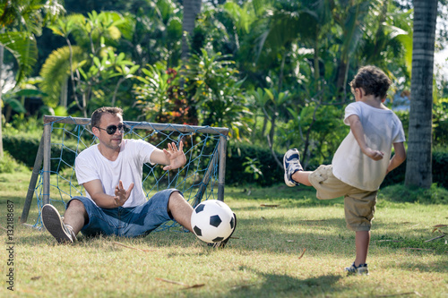 Father and son playing in the park at the day time.