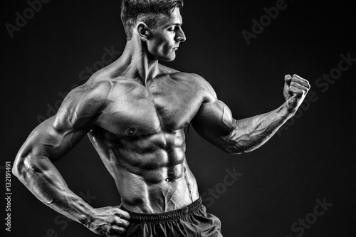 bodybuilder posing. Beautiful sporty guy male power. Fitness muscled man photo