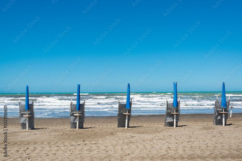 Strand mit Sonnenschirm und Lettini