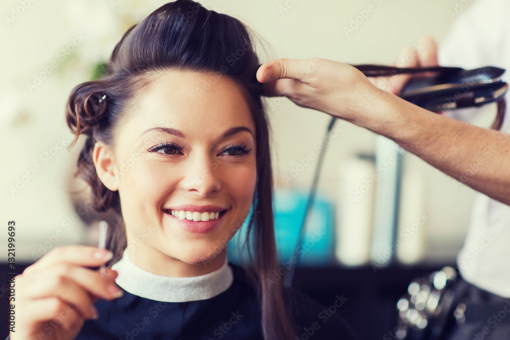Fototapeta premium happy woman with stylist making hairdo at salon