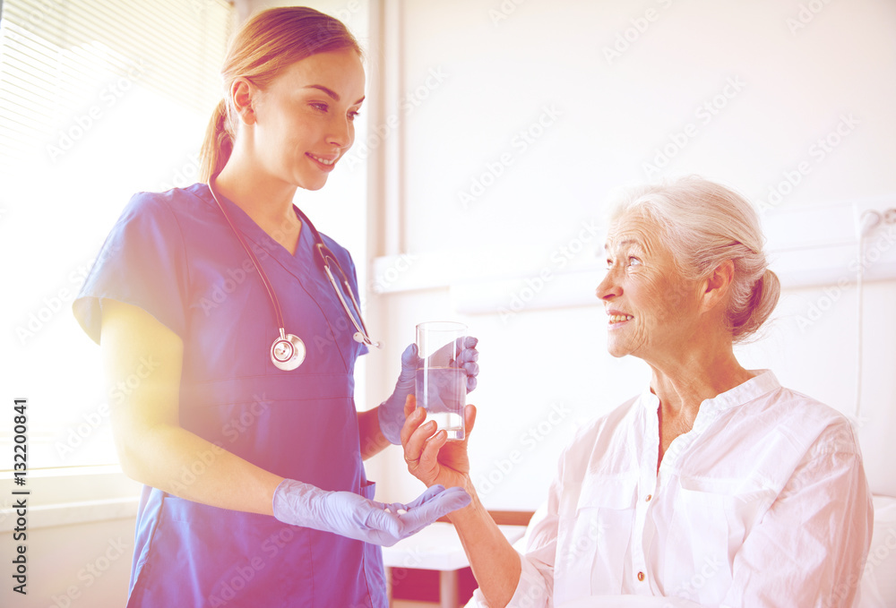 nurse giving medicine to senior woman at hospital nurse giving medicine to senior woman at hospital