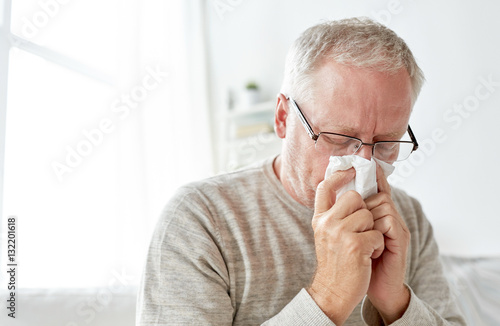 Fototapeta Naklejka Na Ścianę i Meble -  sick senior man with paper wipe blowing his nose