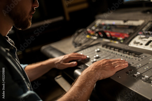 man using mixing console in music recording studio © Syda Productions