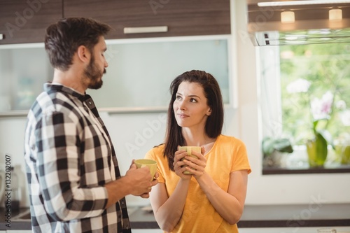 Happy couple having coffee in kitchen photo