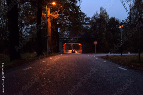 Car driving tunnel at dusk in rural area. Rear view. photo