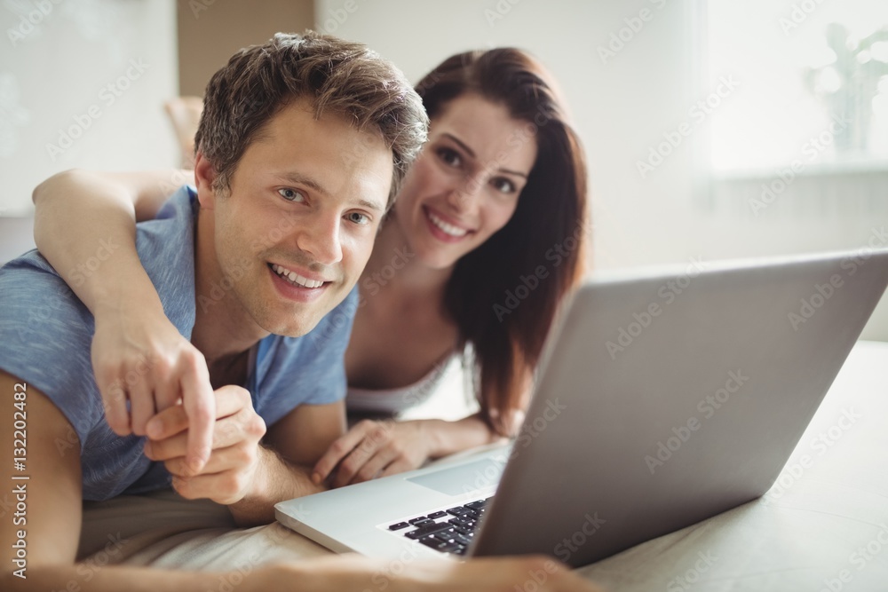 Happy couple using laptop on bed Happy couple using laptop on bed