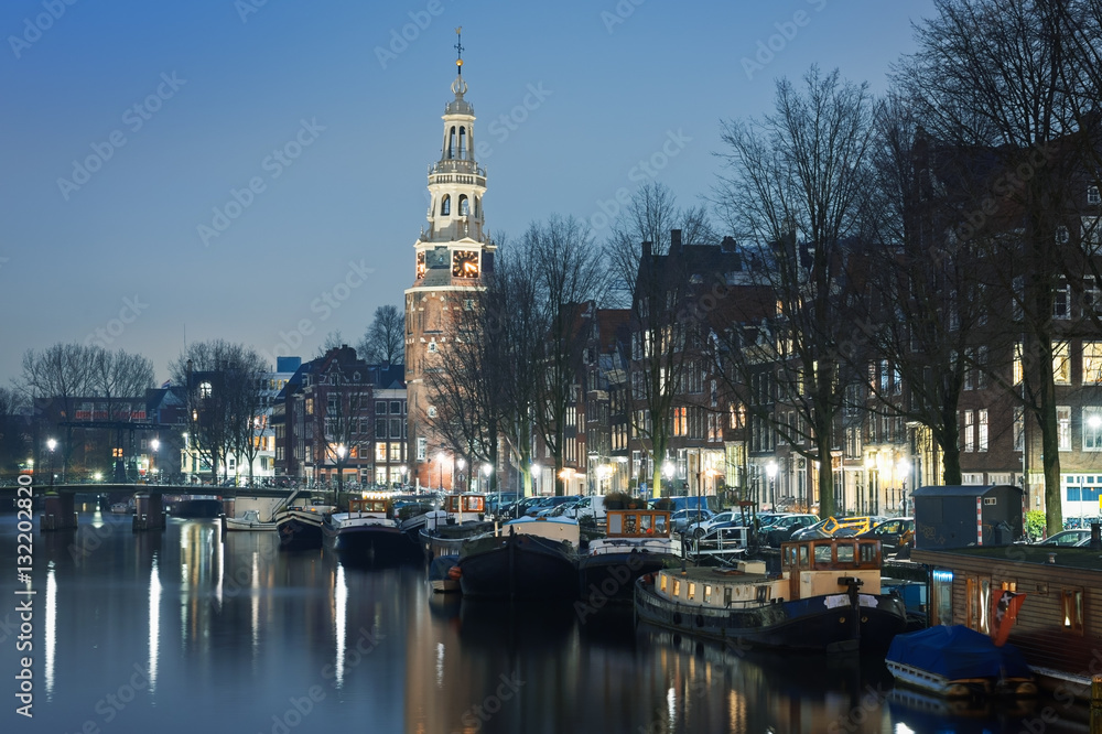Embankment in Amsterdam with church in the blue evening light, the Netherlands