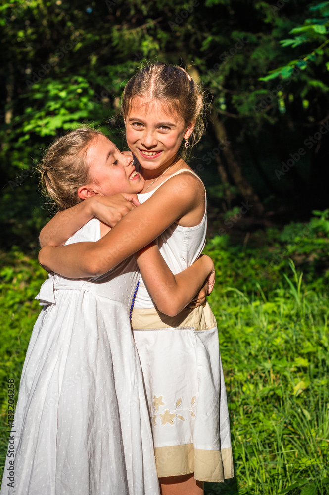 Fototapeta premium two beautiful daughters hugging and dancing in the park