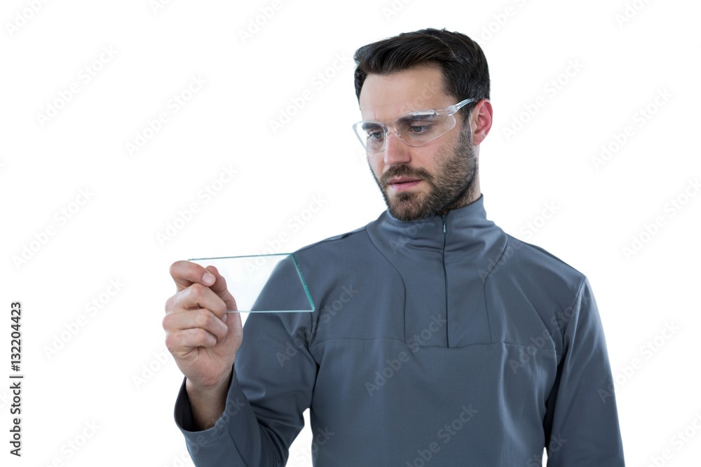 Man wearing protective eyewear holding a glass sheet Man wearing protective eyewear holding a glass sheet
