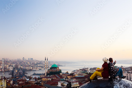 Sunrise View of large eastern City and Couple sitting on Roof