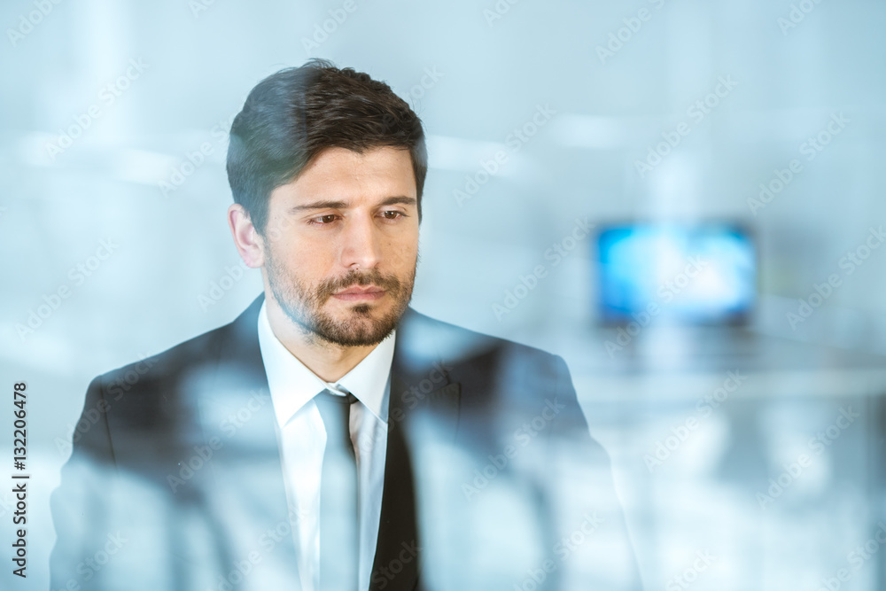 The thoughtful businessman stand near the window The thoughtful businessman stand near the window