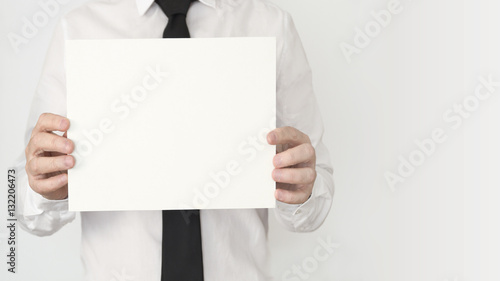 A young business man with a tie holding an empty card with copy space.