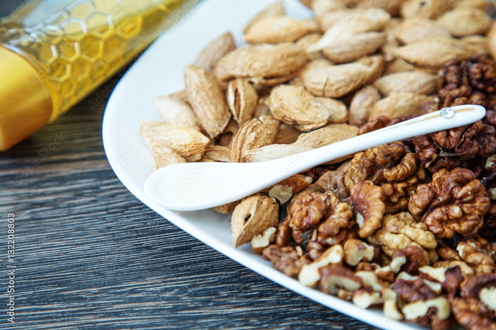 Nuts on a white plate and honey Nuts on a white plate and honey