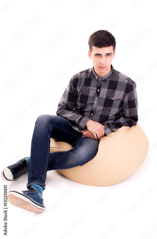Man with angry face sit in big soft chair isolated Man with angry face sit in big soft chair isolated