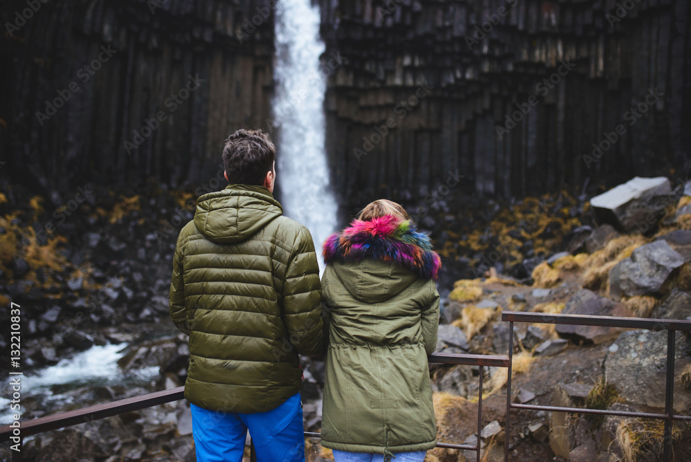 Man and Woman Looking at Waterfall