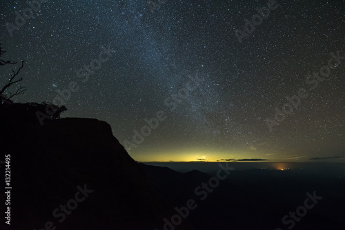 The milky way illuminated above the dark silhouette of the mountain.