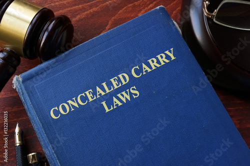 Concealed Carry Laws title on a book and gavel.