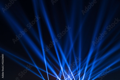 Blue lights of the spotlight from the stage at a concert photo