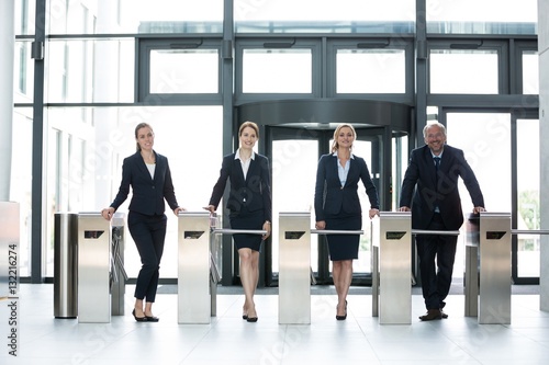Businesspeople standing at turnstile gate photo
