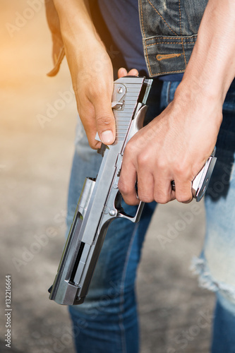 Man in jeans holding a gun