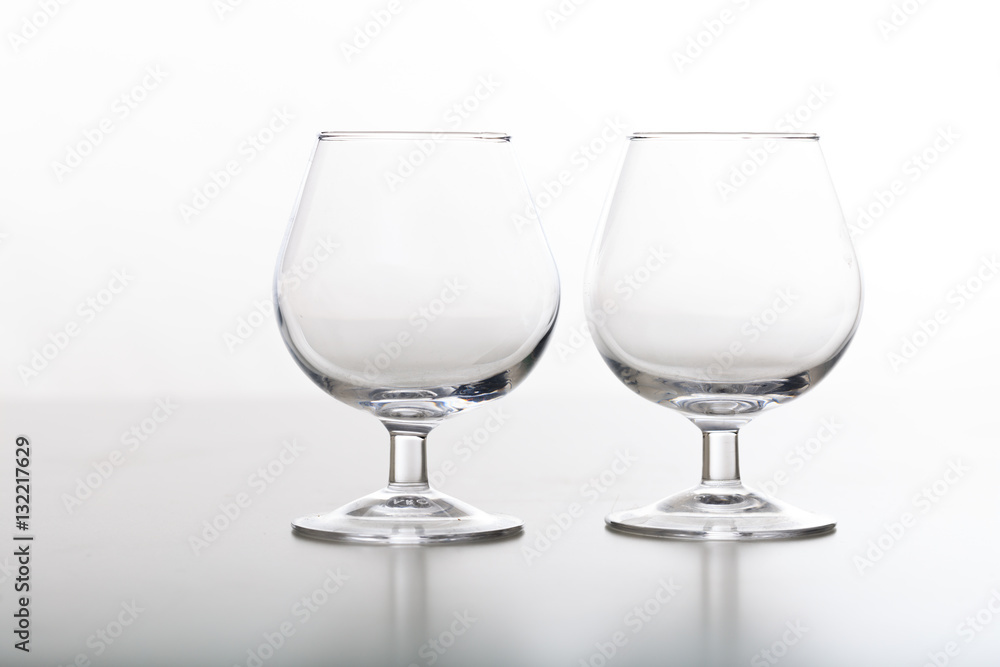 Two empty cognac glasses on white background Two empty cognac glasses on white background