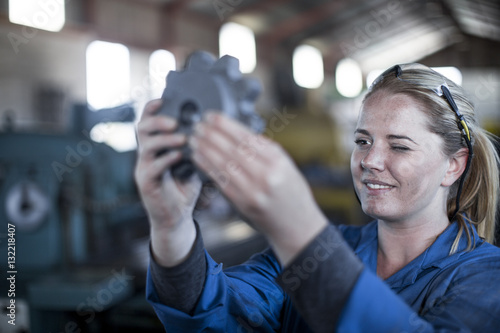 Woman in workshop looking at giant nut photo