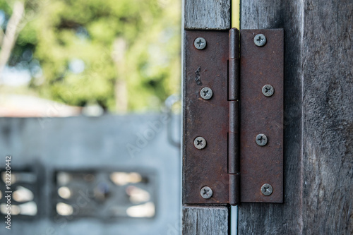 Close up of rusty hinge on the old wooden door