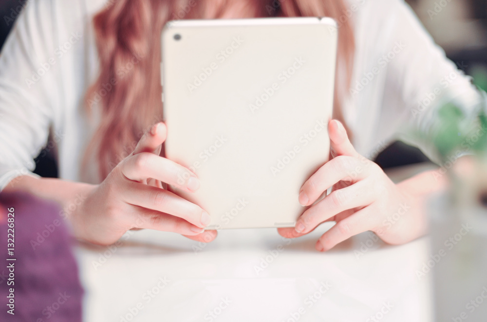 Beautiful woman with long hair is watching into the tablet Beautiful woman with long hair is watching into the tablet