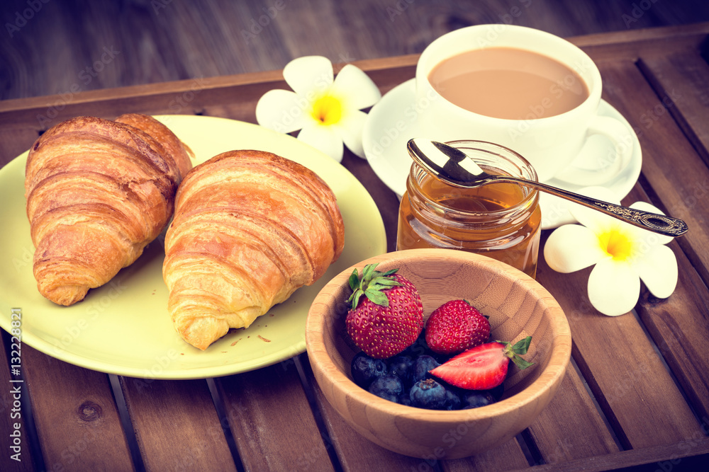 Cup of coffee and croissants on wooden background. Toned image Cup of coffee and croissants on wooden background. Toned image